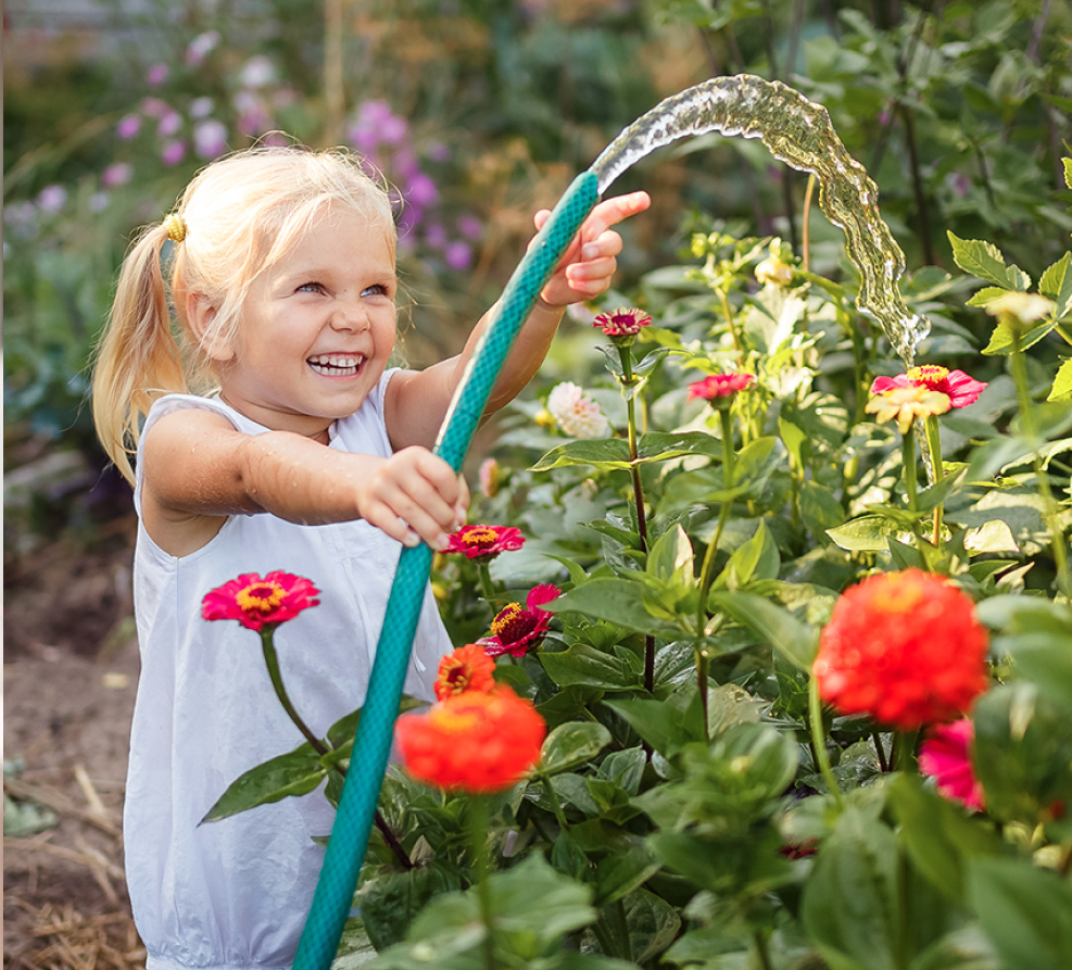 little girl excited to water plants so they can grow