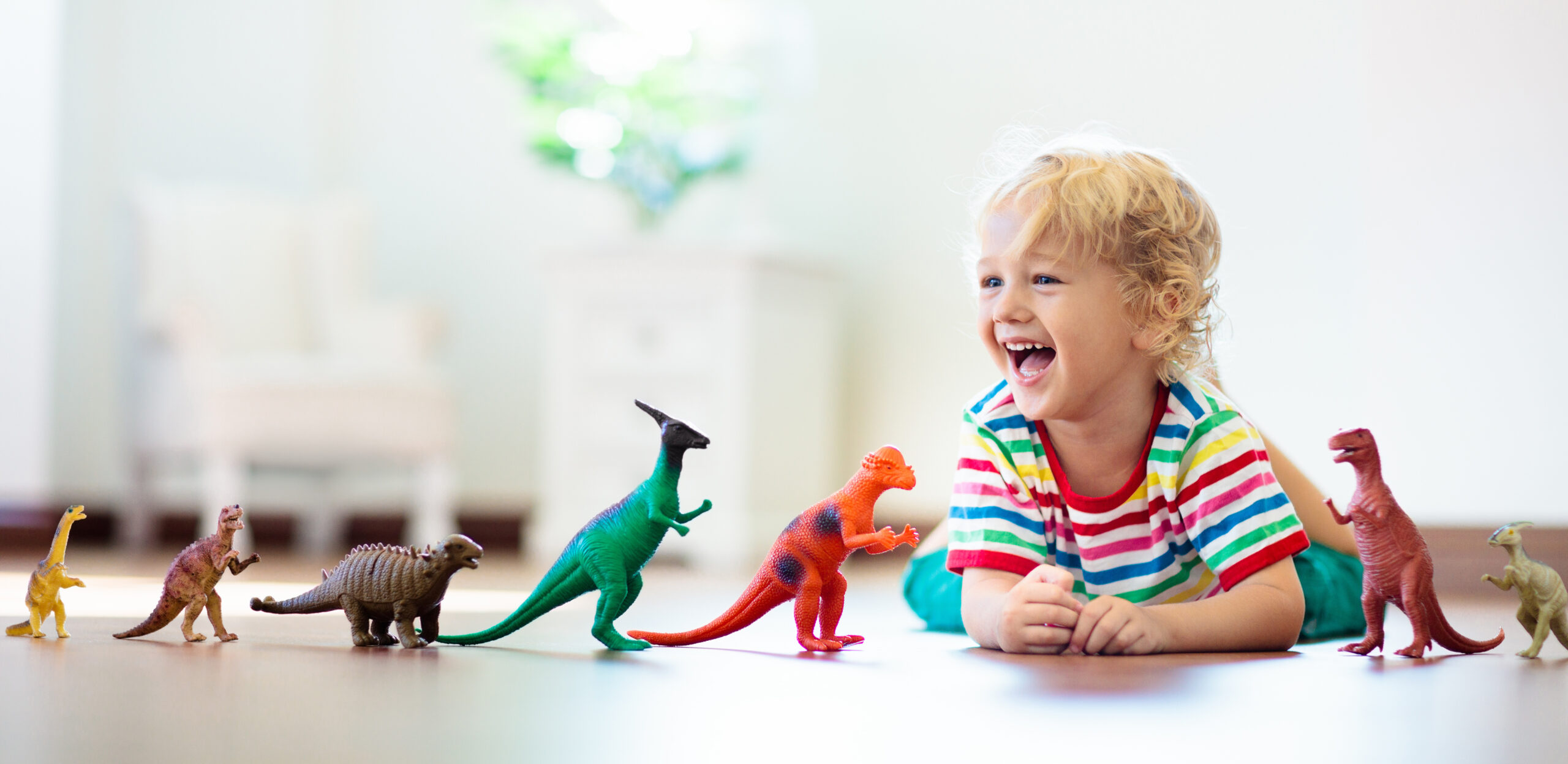 Little boy playing with dinosaur toys