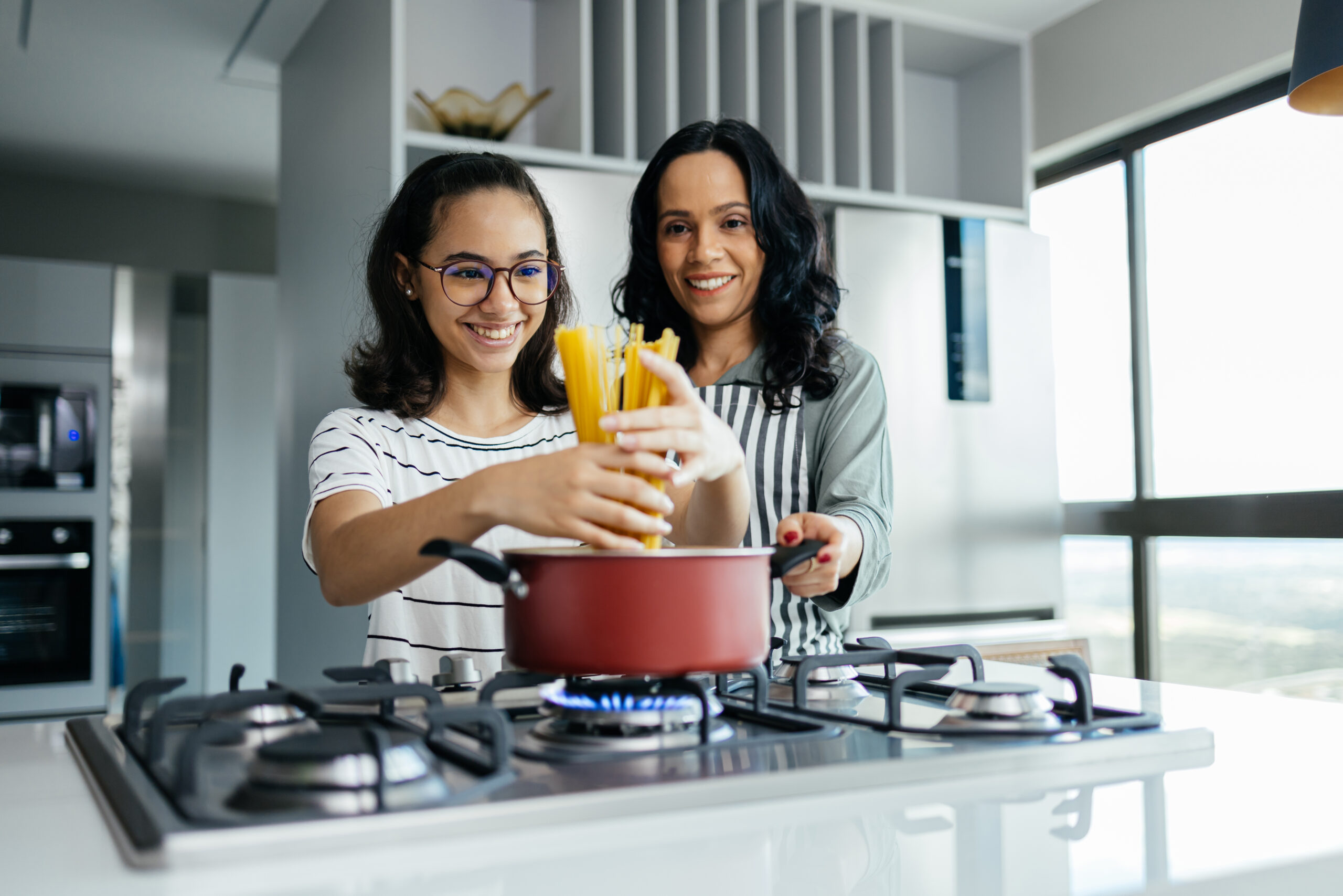 Mother and daughter cooking pasta