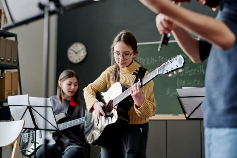 Girl playing guitar in music class